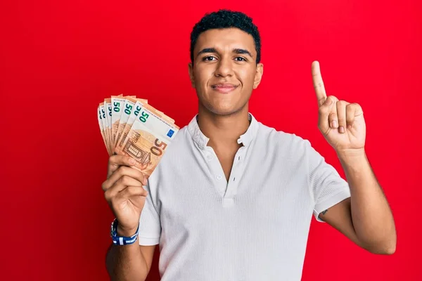 Joven Árabe Sosteniendo Billetes Euros Sonriendo Con Una Idea Pregunta —  Fotos de Stock