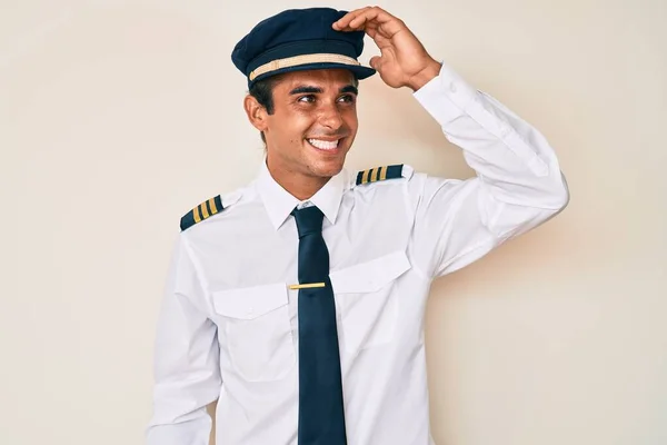 Młody Latynos Mundurze Pilota Samolotu Uśmiechający Się Pewnie Dotykając Włosów — Zdjęcie stockowe