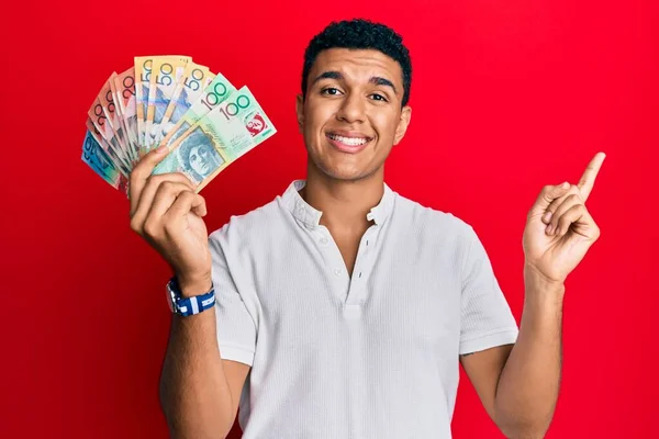 Joven Árabe Sosteniendo Dólares Australianos Sonriendo Feliz Señalando Con Mano —  Fotos de Stock