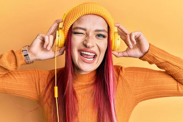Mujer Caucásica Joven Escuchando Música Usando Auriculares Guiñando Ojo Mirando — Foto de Stock