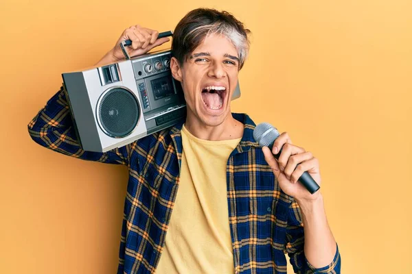 Genç İspanyol adam mikrofon ve teyp kullanarak şarkı söylüyor çılgınlığı kutluyor ve başarıyı hayretle haykırıyor heyecanla haykırıyor. 