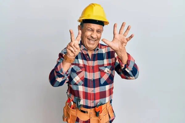 Senior Hispánský Muž Kutilské Uniformě Ukazuje Ukazuje Prsty Číslo Sedm — Stock fotografie