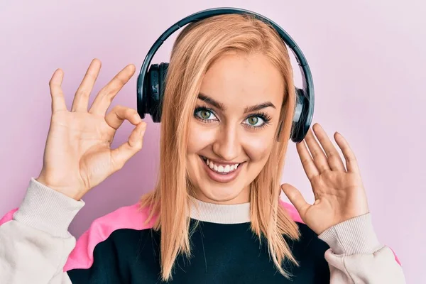 Mulher Branca Bonita Ouvindo Música Usando Fones Ouvido Fazendo Sinal — Fotografia de Stock