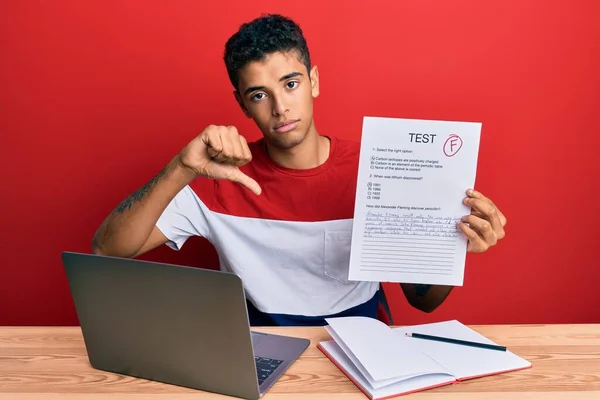 Young handsome african american man showing failed exam with angry face, negative sign showing dislike with thumbs down, rejection concept