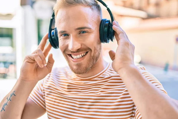 Jovem Irlandês Sorrindo Feliz Ouvindo Música Usando Fones Ouvido Rua — Fotografia de Stock