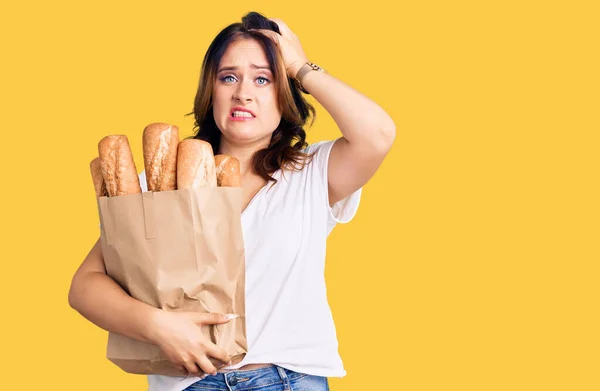 Joven Hermosa Mujer Caucásica Sosteniendo Bolsa Papel Con Pan Estresado — Foto de Stock