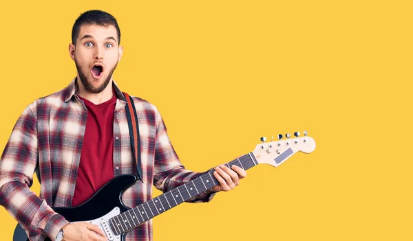 Young Handsome Man Playing Electric Guitar Scared Amazed Open Mouth — Stock Photo, Image
