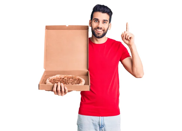 Young Handsome Man Beard Holding Delivery Cardoboard Italian Pizza Surprised — Stock Photo, Image