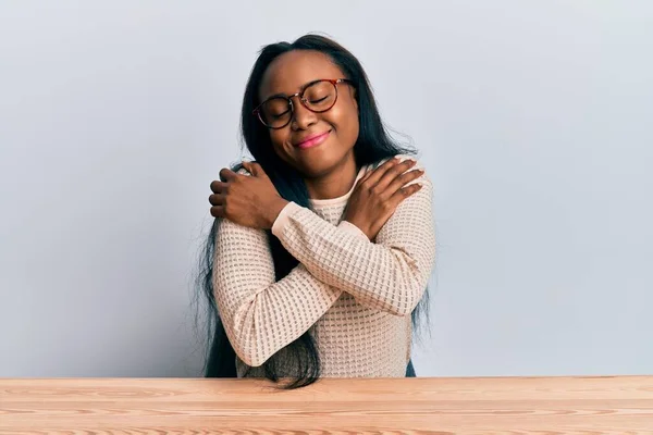 Молода Африканка Повсякденному Одязі Сидячи Столі Обіймає Себе Щасливим Позитивним — стокове фото