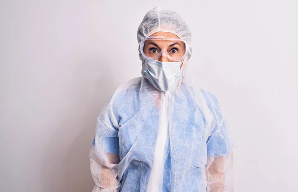中年看護師の女性身に着けています保護コロナウイルス装置白い背景恐怖と驚きの表情でショックを受けました 恐怖と興奮顔 — ストック写真