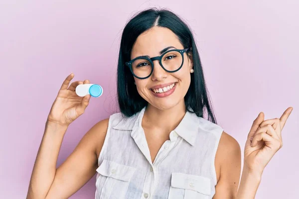 Vacker Ung Kvinna Håller Glasögon Och Kontaktlinser Ler Glad Pekar — Stockfoto