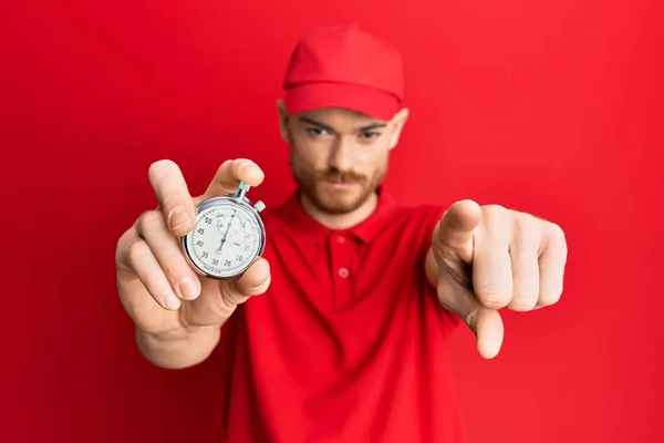 Ung Rödhårig Man Bär Leverans Uniform Och Nedräkning Klocka Pekar — Stockfoto