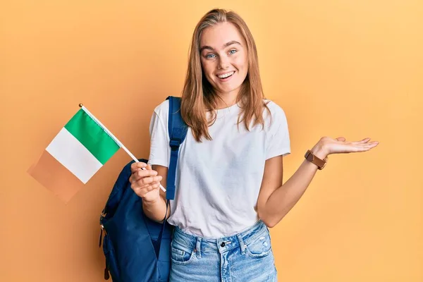 Hermosa Mujer Rubia Estudiante Intercambio Sosteniendo Bandera Irlanda Celebrando Logro —  Fotos de Stock