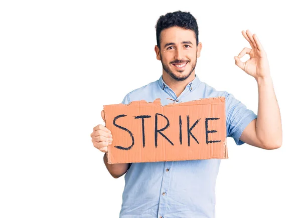 若いヒスパニック系の男は指でOkサインを行うストライキバナー段ボールを保持し 優れたシンボルをジェスチャーフレンドリーな笑顔 — ストック写真
