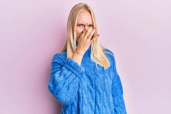 Young Blonde Girl Wearing Wool Winter Sweater Smelling Something Stinky — Fotografia de Stock