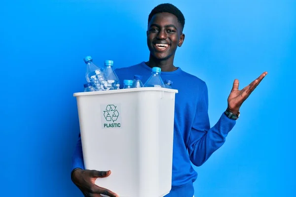 Młody Afrykański Amerykanin Trzymający Kosz Śmieci Plastikowymi Butelkami Świętujący Zwycięstwo — Zdjęcie stockowe
