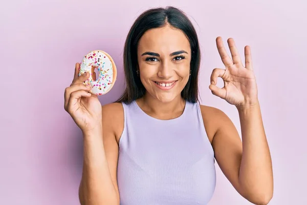 Young Brunette Woman Holding Tasty Colorful Doughnut Doing Sign Fingers — Foto de Stock