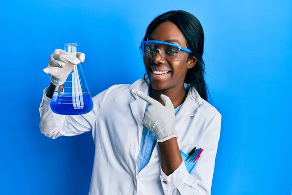 若いですアフリカ系アメリカ人女性身に着けています科学者制服保持テストチューブ笑顔幸せなポインティングとともに手と指 — ストック写真