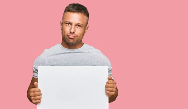 Knappe Spier Man Met Lege Banner Denken Houding Nuchtere Uitdrukking — Stockfoto