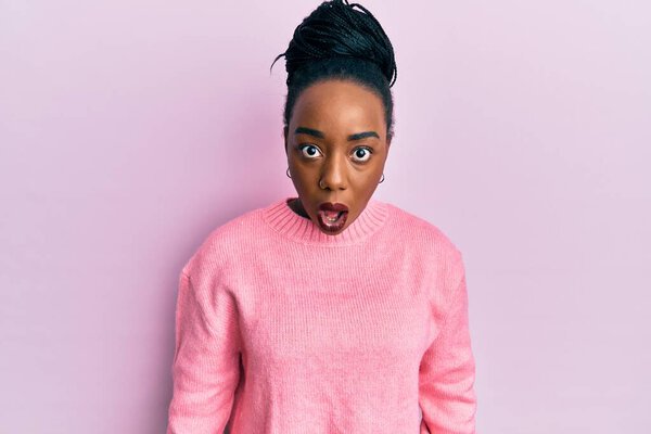 Young african american woman wearing casual winter sweater afraid and shocked with surprise and amazed expression, fear and excited face. 