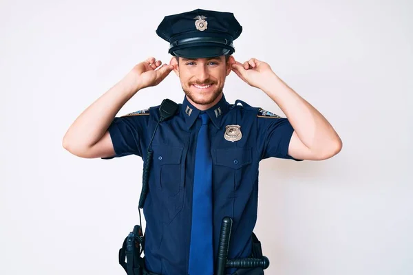 Ung Kaukasisk Man Klädd Polisuniform Leende Dra Öron Med Fingrar — Stockfoto