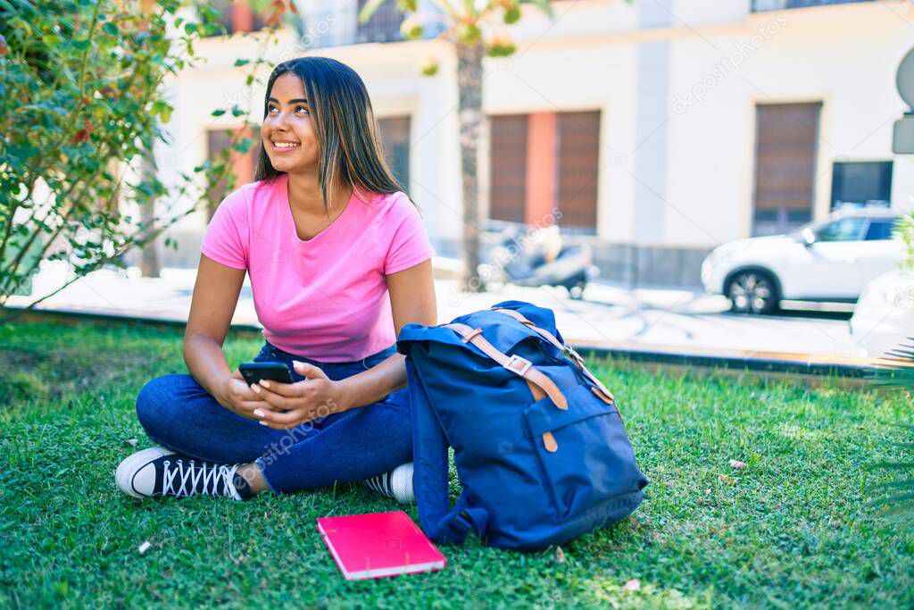Young latin student girl smiling happy using smartphone at university campus.