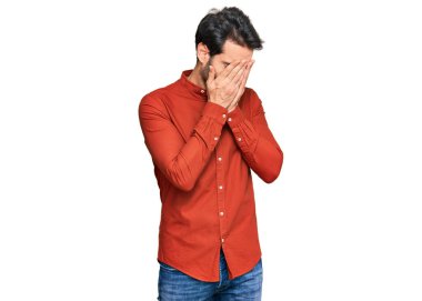 Ağlarken suratını ellerle kapatan, günlük kıyafetler giyen genç İspanyol. depresyon kavramı. 