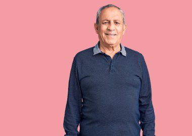 Yüzünde mutlu ve havalı bir gülümseme olan sıradan polo giyen son sınıf yakışıklı adam. şanslı kişi. 
