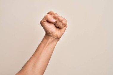 Beyaz arka planda protesto ve devrim hareketi yapan, güç ve güç gösterisi yapan beyaz tenli bir gencin eli.