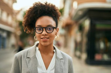 Genç Afrikalı Amerikalı iş kadını şehirde mutlu bir şekilde dikiliyor..
