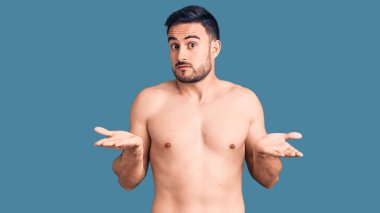 Mayo giyen genç, yakışıklı adam habersiz ve kolları açık, hiçbir fikri yok.. 