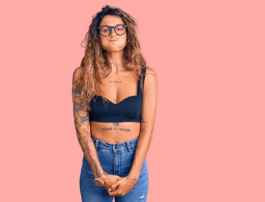 Gündelik kıyafetler giyen, gözlüklü, komik yüzlü, yanakları şişen İspanyol bir kadın. Havayla şişmiş ağız, çılgın bir ifade.. 