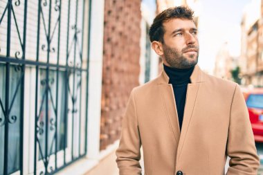 Dışarıda şık bir ceket giyen yakışıklı bir iş adamı.