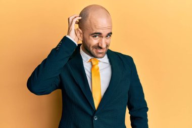 İş elbisesi giyen ve kravat takan İspanyol genç adam soru sorup kafasını karıştırıyor. Şüpheyle kararsız, kafa kafaya düşünerek. Düşünceli kavram. 