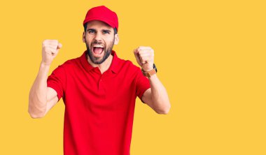 Sakallı, teslimat üniforması giyen kızgın ve kızgın genç bir adam öfkeyle bağırırken yumruklarını kaldırıyor. öfke ve agresif konsept. 