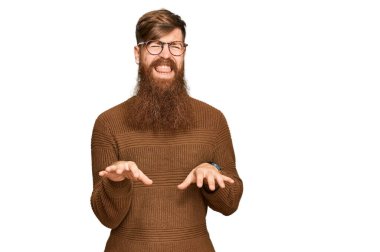 Genç İrlandalı kızıl adam gündelik kıyafetler ve gözlük takıyor. İğrenç bir ifade takınıyor ve tiksindirici bir yüz ifadesi takınıyor.. 