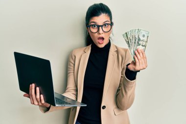 İş tarzı dizüstü bilgisayar giyen İspanyol bir kadın ve 50 Euro 'luk şok suratlı, şüpheci ve alaycı bakışlı, ağzı açık bir şekilde şaşırmış. 