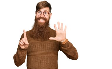 Genç İrlandalı kızıl elbiseli ve gözlüklü adam altı numaralı parmaklarını gösterip gösterirken kendinden emin ve mutlu gülümsüyor.. 