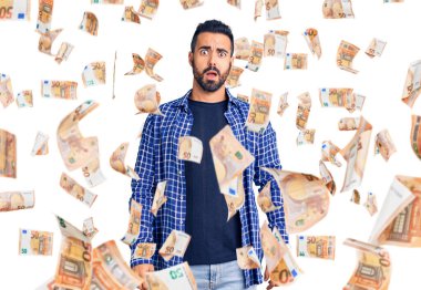 Şok olmuş gibi giyinen genç İspanyol adam şüpheci ve alaycı görünüyor, ağzı açık kalınca şaşırıyor.