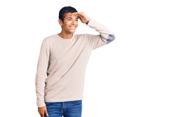 Genç Afro-Amerikan bir adam günlük giysiler giyiyor çok mutlu ve gülümsüyor başlarını kaldırıp uzaklara bakıyor. arama kavramı. 