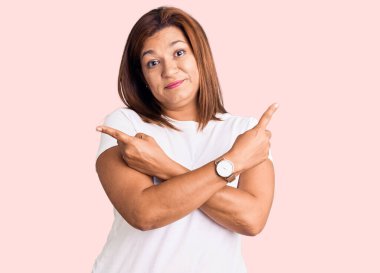 Orta yaşlı, sıradan kıyafetler giyen, gülümseyen ve parmaklarıyla gözlerini kaçıran güzel bir kadın..