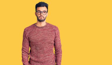 Kışlık süveter giyen ve gözlüklü genç, yakışıklı bir İspanyol bunalımlı ve endişeli, sinirli ve korkmuş. hüzünlü ifade. 