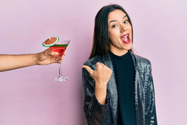 Seksi parti ceketi giymiş genç bir kız ve İspanyol bir kol. Kokteyl ikram ediyor. Başparmağını kaldırıp gülümsüyor ve ağzı açık. 