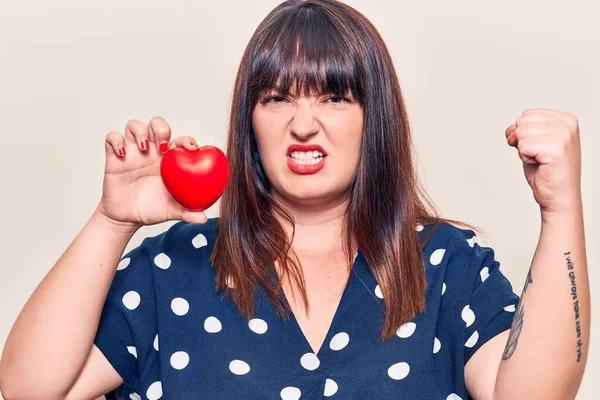 Kalbini tutan iri yarı genç bir kadın öfkeyle bağırıyor, öfkeyle bağırıyor ve el kaldırıyor. 