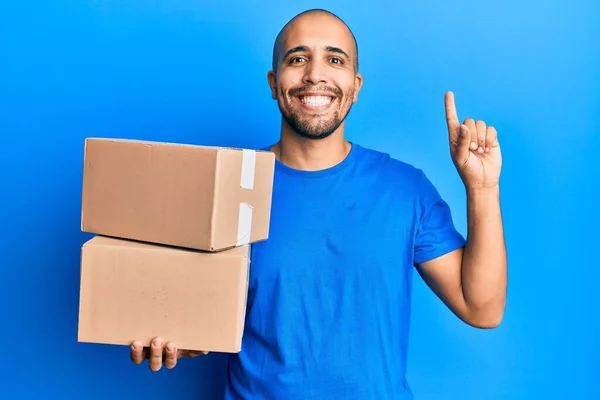 Hombre Adulto Hispano Sosteniendo Paquetes Sobre Fondo Azul Sonriendo Con — Foto de Stock