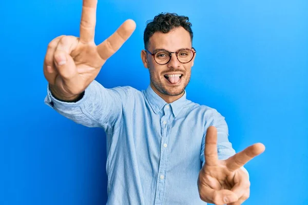 Jovem Hispânico Vestindo Roupas Casuais Óculos Sorrindo Com Língua Para — Fotografia de Stock