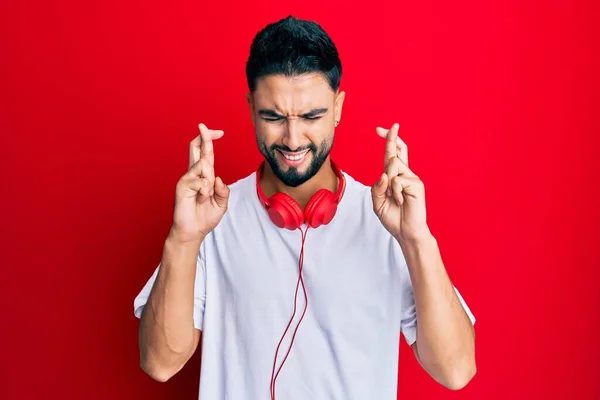 Fiatal Férfi Szakállal Zenét Hallgat Fejhallgatóval Gesztikuláló Ujját Keresztbe Mosolygott — Stock Fotó