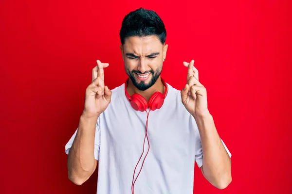 Joven Con Barba Escuchando Música Usando Auriculares Haciendo Gestos Con —  Fotos de Stock