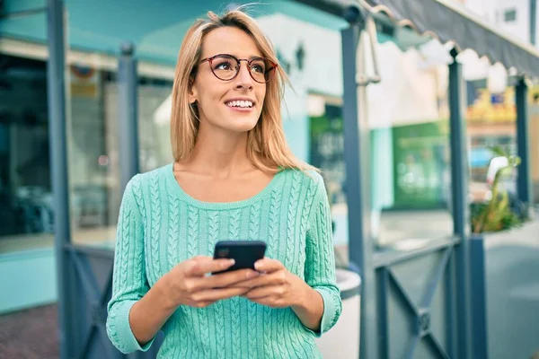 Mujer Rubia Joven Sonriendo Feliz Usando Teléfono Inteligente Ciudad — Foto de Stock