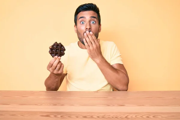 Young Hispanic Man Holding Chocolate Waffle Sitting Table Covering Mouth — Stock Photo, Image